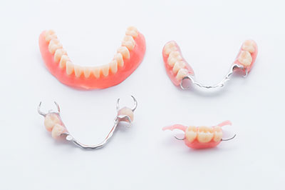 The image displays a set of dentures with teeth that are missing, arranged in two rows against a white background.