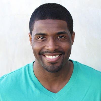 Two elderly individuals, a man and a woman, are sitting closely together with smiles on their faces, showcasing a moment of affection and contentment.