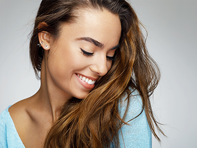 A woman with long hair, smiling slightly, against a neutral background.