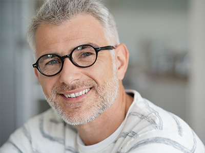 A middle-aged man with glasses and a beard, smiling at the camera.