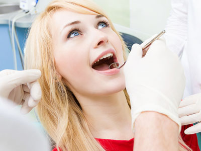 A young woman receiving dental care, with a dentist performing the procedure.