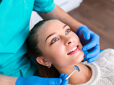 Dental hygienist performing a cleaning procedure on a patient s teeth.